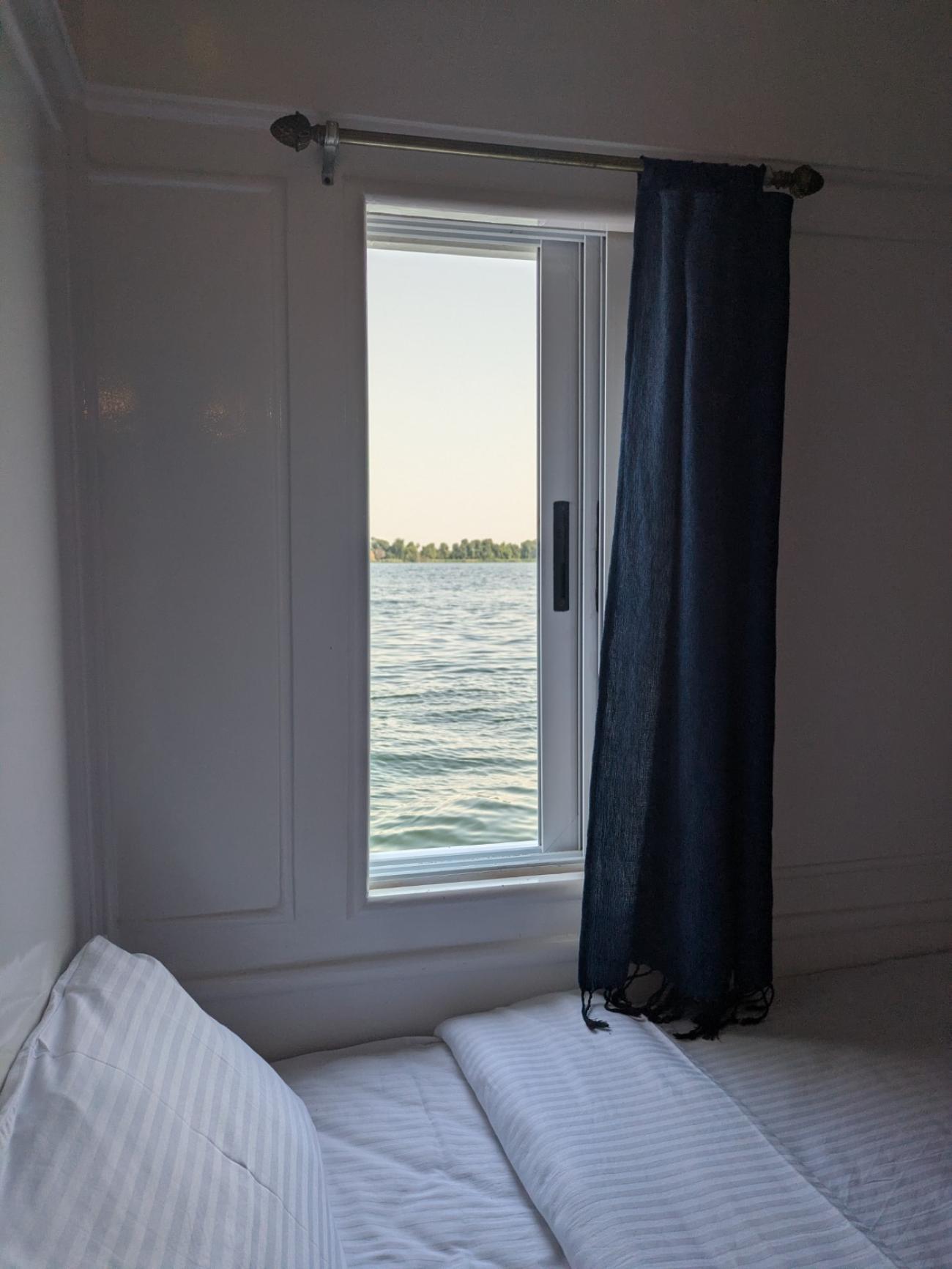 Boat cabin with window by the bed with view of the Nile